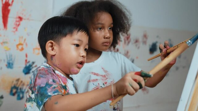 Happy creative african girl painted or draw canvas together with asian boy. Group of playful student create funny painting or artwork painted by watercolor. Creativity activity concept. Erudition.