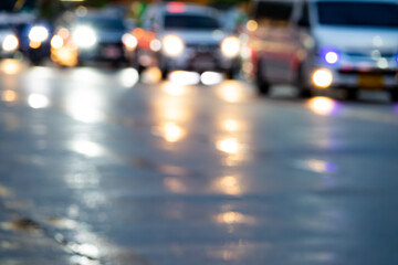 A blurry image of a busy street at night with cars and trucks. The lights from the vehicles create a hazy, dreamy effect