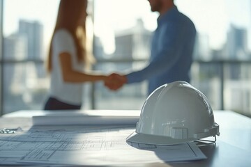 Business partnership agreement in a modern office with construction plans and hard hat