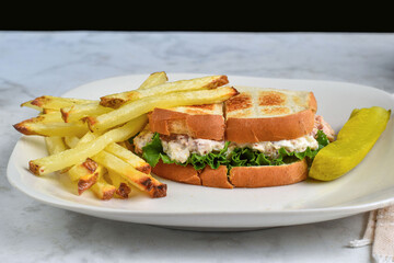 chicken salad sandwich  with frie and pickle