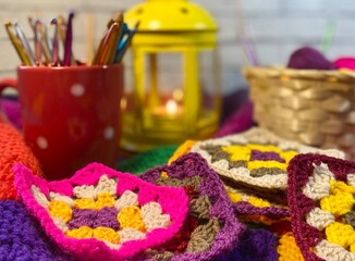 Crochet granny square motives set on the table, clews and hooks and basket cozy home photo