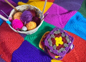 Crochet granny square motives set on the table, clews and hooks and basket cozy home photo