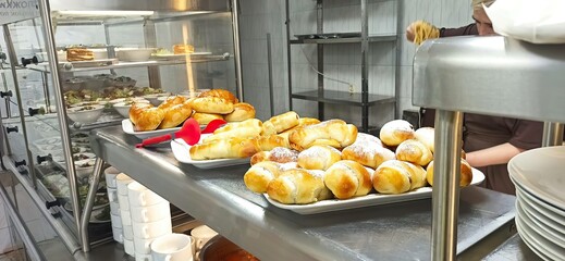 Freshly baked goods displayed in a bustling kitchen during lunchtime service