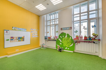 Bright interior decor of a kindergarten room. A room with large windows for games and .learning.