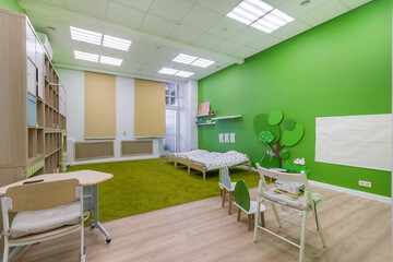The interior of the kindergarten room. Bright green decor. Special furniture for kids.