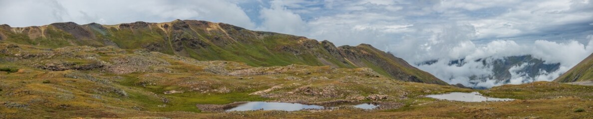 mountain tundra ponds with low clouds and overcast skies