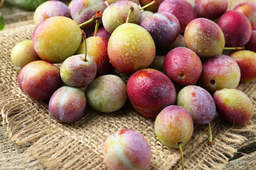 Pile of tasty ripe plums on table, closeup