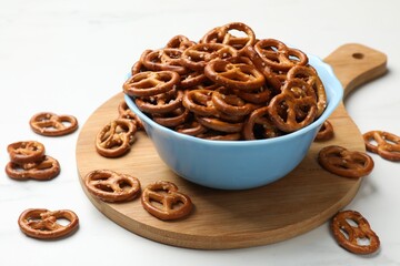 Tasty pretzel crackers on white table, closeup