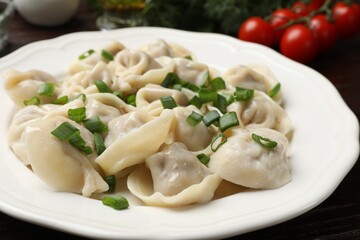 Delicious pelmeni with green onion on table, closeup