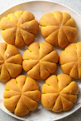 Tasty pumpkin shaped buns on grey table, top view
