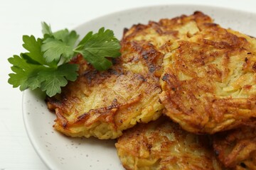 Delicious potato pancakes and parsley on table, closeup