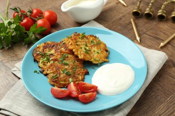 Delicious potato pancakes, menorah and candles on wooden table, closeup. Hanukkah festive food
