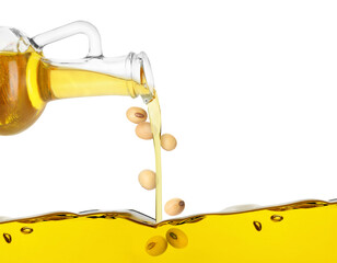 Vegetable oil and soy beans pouring from glass jug on white background