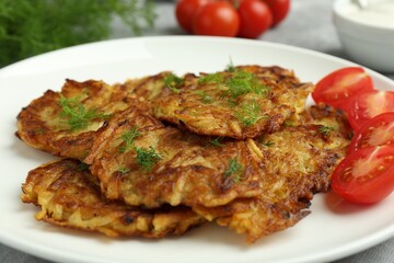 Delicious potato pancakes with fresh tomatoes and dill on table, closeup