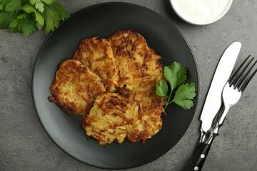 Delicious potato pancakes served on grey table, flat lay