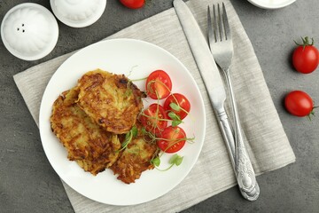 Delicious potato pancakes served on grey table, flat lay