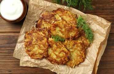 Delicious potato pancakes served on wooden table, flat lay