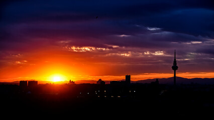 Panoramic view of the skyline of the city of Madrid at sunset with reddish tones and the profile of the piruli