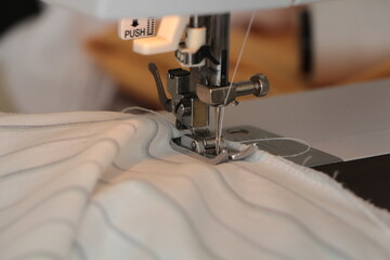 Closeup the sewing machine and item of clothing. View of sewing process. Production line sewing machine. Needle and footstep detail. Fashion design, sewing and hobby concept. striped fabric on white