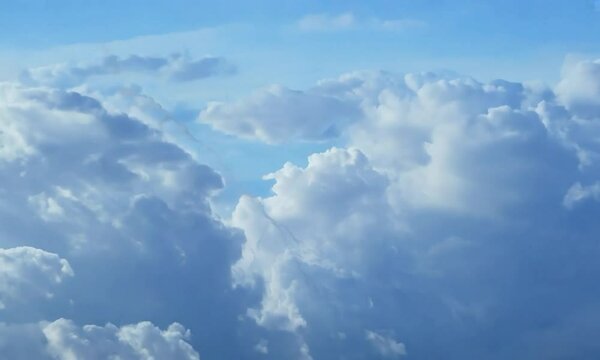 Close-up shot with intricate cloud formations: The camera starts by focusing on detailed and intricate cloud formations, then pulls back to show the larger sky scene.
