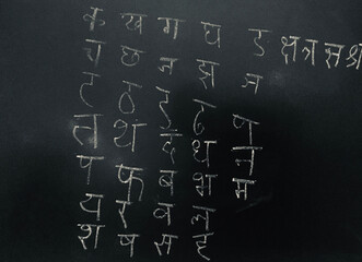 Hindi Script Handwritten by child on Blackboard as Learning to write with Translation: Written...