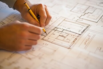 Architect drawing detailed building plans on paper