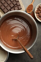 Chocolate dough in bowl and ingredients on grey table, flat lay
