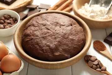 Chocolate dough and ingredients on white wooden table, closeup