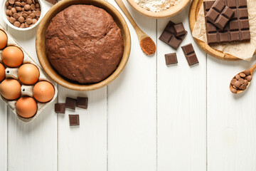 Chocolate dough and ingredients on white wooden table, flat lay. Space for text