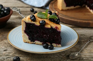 Slice of homemade blueberry pie on wooden table, closeup