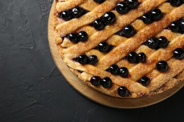 Delicious homemade blueberry pie on black table, top view