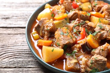 Delicious stew with vegetables on wooden table, closeup