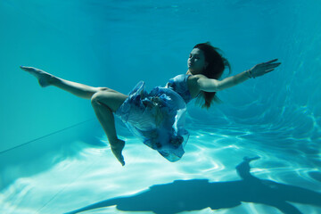 Portrait of woman in blue dress posing underwater