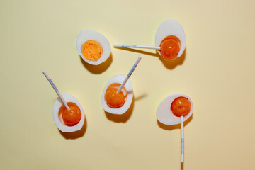 Egg made from boiled egg whites and orange lollipops. Flat lay