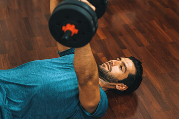 Athletic body and active sporty man lifting dumbbell weight for effective targeting muscle gain at...