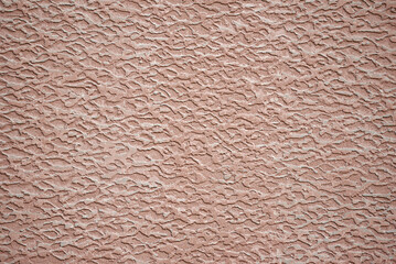 Texture of wall with decorative rough pink putty. Decorative putty sample on the wall with abstract...