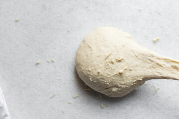 overhead view of dough being stretched to check if has been kneaded enough, bread dough being stretched to check for gluten development