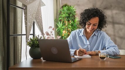 Mature caucasian woman work or learn use notebook and laptop from home