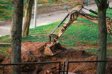 An excavator digs into the earth, showcasing heavy machinery at work on a construction site, demonstrating power and efficiency in action.