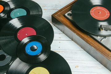 Old record player next to several vinyl records