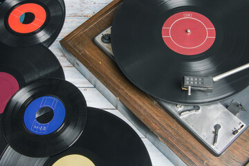 Old record player next to several vinyl records