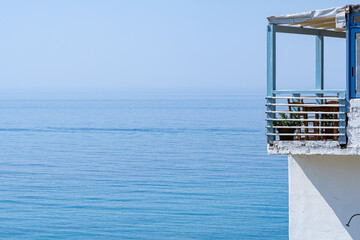 Beach house balcony and endless sea with clear blue sky in sunshine telephoto