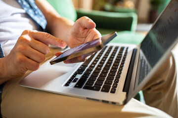 Man multitasking on laptop and smartphone at home