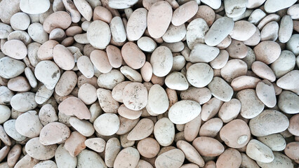 The round river stones are white and smooth. Stone background concept.