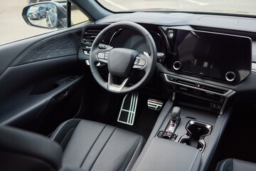 Closeup of a modern car steering wheel with control buttons for technology and convenience