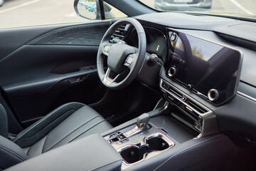 Closeup of a modern car steering wheel with control buttons for technology and convenience