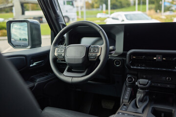 Closeup of a modern car steering wheel with control buttons for technology and convenience