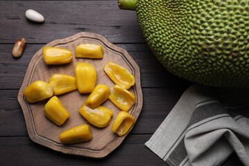 Fresh exotic jackfruit on black wooden table, flat lay