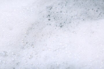 Detergent foam as background, closeup. Hand washing laundry