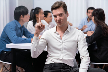 Obraz premium Confidence and happy smiling businessman portrait with background of his colleague and business team working in office. Office worker teamwork and positive workplace concept. Prudent